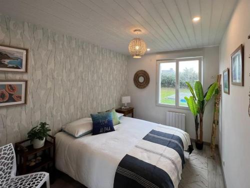 um quarto com uma cama e uma janela em Jolie Villa avec piscine chauffée 8 par 4 m em Erdeven