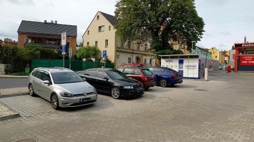 una fila de autos estacionados en un estacionamiento en Apartment Gato, en Karlovy Vary