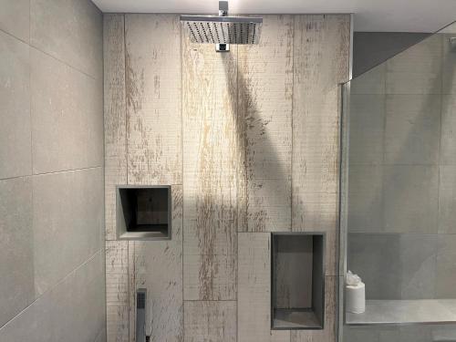 a shower in a bathroom with a white tiled wall at Spacious Apartment~Parking~Close to Seafront in Penzance
