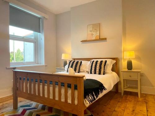 a bedroom with a crib and a window at Bright & Spacious Edwardian Townhouse with Garden in Truro