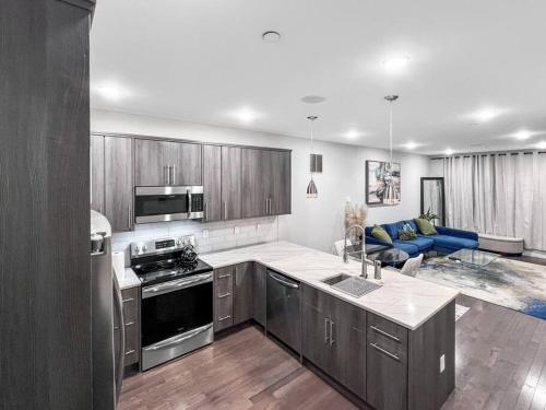 een keuken met roestvrijstalen apparatuur en een woonkamer bij Yanne's Place - Dual-Lounge in Philadelphia