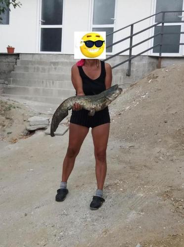 a woman wearing a hat and holding a snake at Bungalow- casute in Orşova