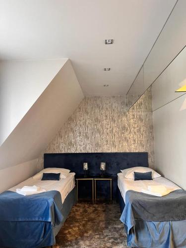 a attic room with two beds and a table at Hotel & Spa Biały Dom in Gliwice