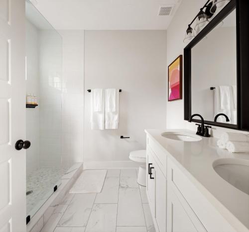 een witte badkamer met een wastafel en een toilet bij Golden Hour in St. Augustine