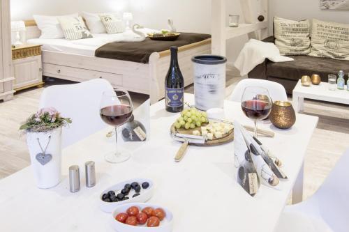 einen weißen Tisch mit Gläsern aus Wein und Trauben in der Unterkunft Schwalbennest in Flensburg