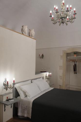 ein Schlafzimmer mit einem schwarzen und weißen Bett mit einem Kronleuchter in der Unterkunft Terrazza Campailla in Modica
