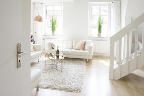 a white living room with a white couch and a table at Auster in Flensburg