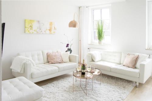 a living room with two white couches and a table at Auster in Flensburg