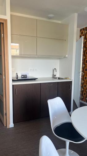 a kitchen with a sink and a table and chairs at Appartement - Galerie POP ART - Trentemoult in Rezé