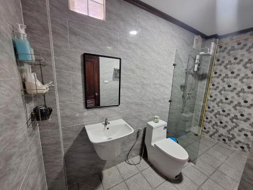 a bathroom with a sink and a toilet and a mirror at Villa KhounSok Sunset in Luang Prabang