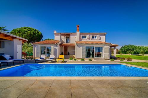 uma villa com piscina em frente a uma casa em Captains House em Fažana