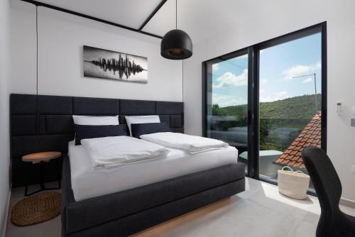 1 dormitorio con cama y ventana grande en Kala, en Ražanac