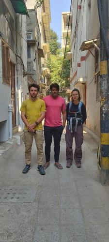 a group of three men walking down a street at Sufi Khandar Home Stay in New Delhi