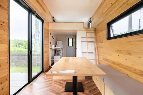 een kleine kamer met een tafel in een tiny house bij FUKUOKA FUKUTSU MUNAKATA YUSUKE HOUSE in Kōnominato