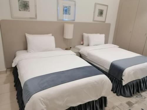 dos camas sentadas una al lado de la otra en una habitación en Kuwait Residence, en Kuwait