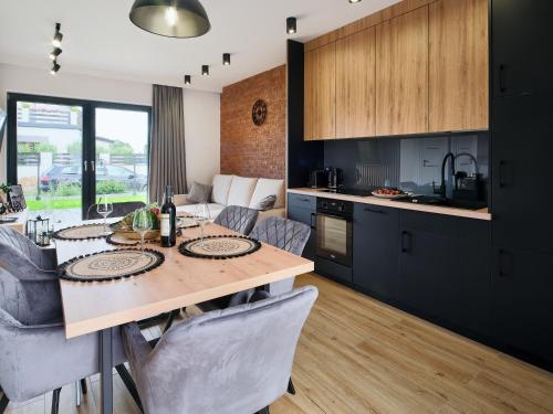 een keuken en eetkamer met een tafel en stoelen bij Apartamenty Marinera in Łeba