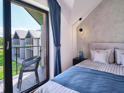 a bedroom with a bed and a large window at Apartamenty Marinera in Łeba