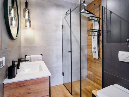 a bathroom with a sink and a shower at Apartamenty Marinera in Łeba