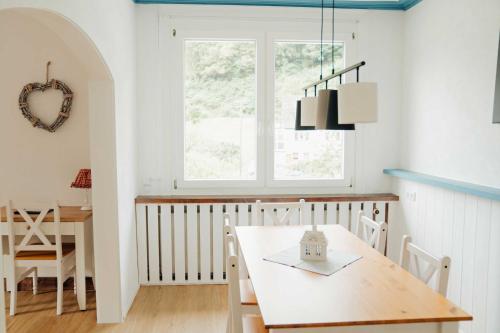 a dining room with a table and a window at Liebevoll Gästewohnungen in Alpirsbach