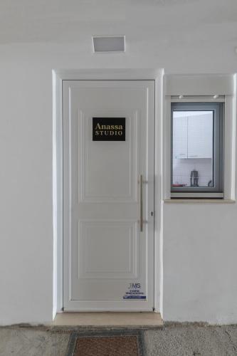 a white door with a sign on it next to a window at Anassa 9 Cozy Apartment in Heraklio Town