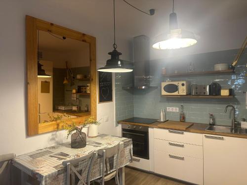 uma cozinha com uma mesa, um lavatório e um espelho em FORNELLS 003 em Es Mercadal
