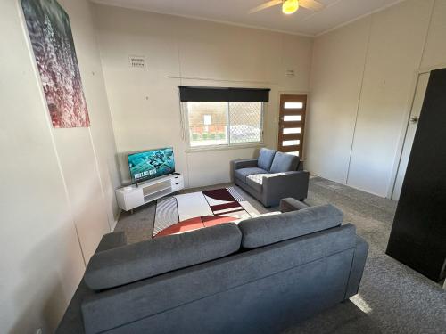 a living room with a blue couch and a tv at 1 Bedroom Apartment near Graftons Waterfront in Grafton