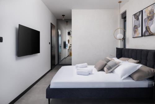 a bedroom with a large white bed and a flat screen tv at Soho in Punta