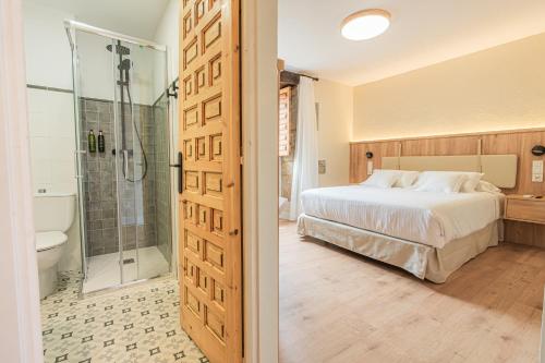 a bedroom with a bed and a shower and a bathroom at Hotel BESTPRICE Santillana in Santillana del Mar