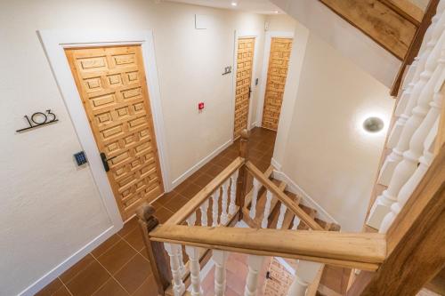 a staircase in a house with a wooden door at Hotel BESTPRICE Santillana in Santillana del Mar