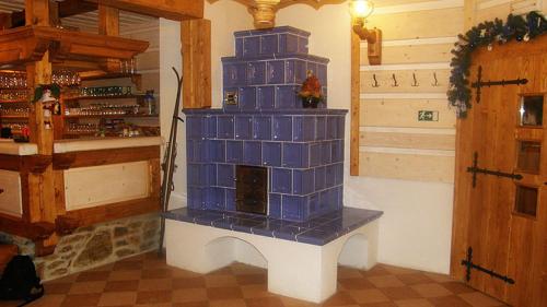 uma sala de estar com uma lareira de azulejos azuis num quarto em Horsky hotel Stumpovka em Rokytnice nad Jizerou