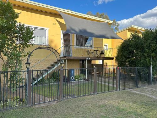a fence in front of a house with a balcony at 1 Bedroom Apartment near Graftons Waterfront in Grafton