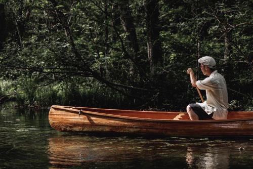 a man sitting in a boat in the water at Urabandai Cranes in Kitashiobara