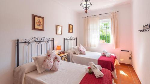 1 dormitorio con 2 camas, sofá y ventana en Casa Rural Marquez Ronda by Ruralidays, en Ronda