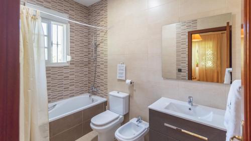 a bathroom with a toilet and a tub and a sink at Casa Rural Marquez Ronda by Ruralidays in Ronda