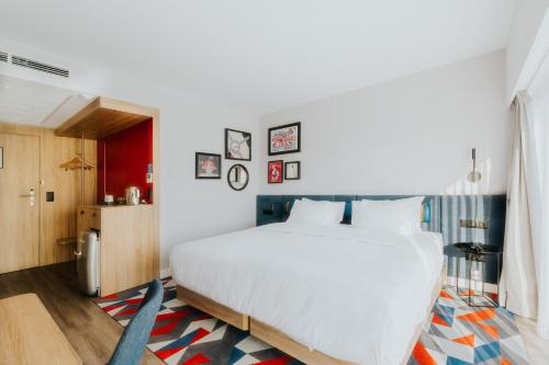 a bedroom with a large white bed in a room at Hampton By Hilton Warsaw Reduta in Warsaw