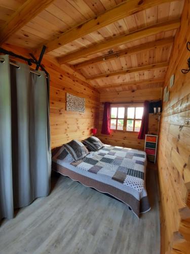 - une chambre dans une cabane en rondins avec un lit dans l'établissement Marne LAC DU DER JOLI CHALET AU CHARME DU DER, à Châtillon-sur-Broué
