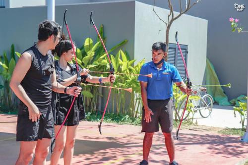 a group of three people holding arrows at Anantara Vacation Club Mai Khao Phuket in Mai Khao Beach