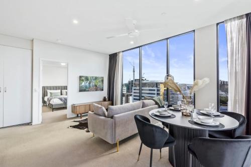 a living room with a couch and a table and chairs at Luxury 2 Bedroom 2 Bathroom in the heart of South Brisbane in Brisbane