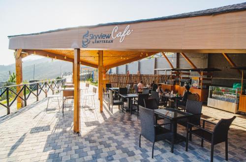 a restaurant with tables and chairs under a roof at Skyview by Empyrean in Patnitop
