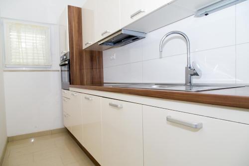 a kitchen with white cabinets and a sink at Villa Ana Sevid in Sevid