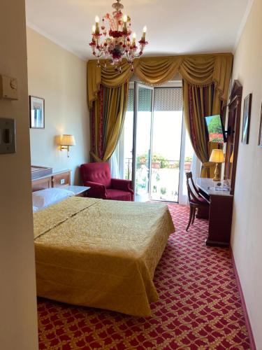 a hotel room with a bed and a chandelier at Hotel Milan Speranza Au Lac in Stresa