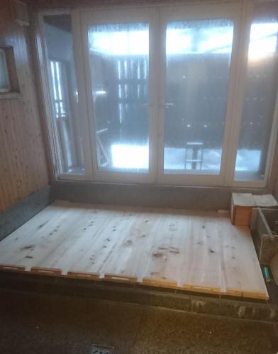 a room with a wooden floor in front of a window at Urabandai Cranes in Kitashiobara