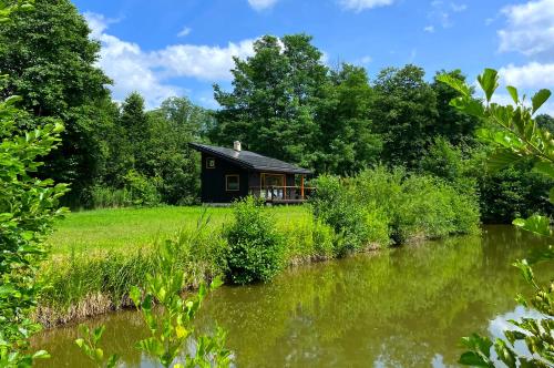 a cabin in the woods next to a river at 3pokoje - Domek lub Pokój pod lasem na odludziu, jacuzzi, sauna, kominek, Roztocze in Susiec