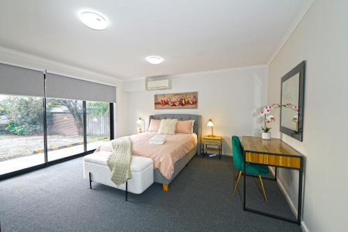 a bedroom with a bed and a table and a desk at Pet Friendly Well-appointed 3BM Retreat Parking Netflix in Ringwood