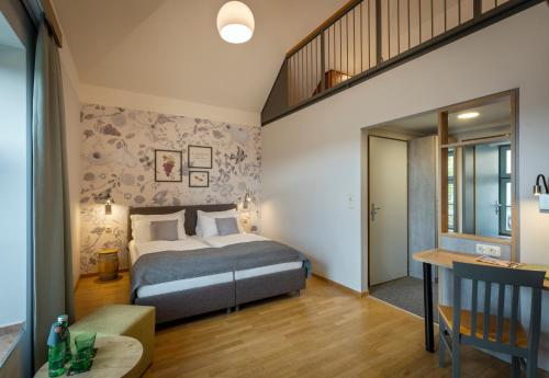 a bedroom with a king sized bed and a staircase at JUFA Hotel Deutschlandsberg in Deutschlandsberg