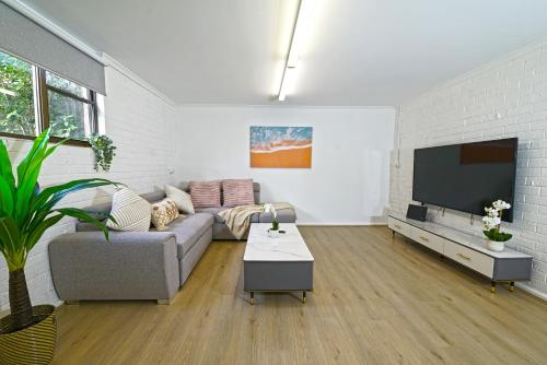 a living room with a couch and a flat screen tv at Pet Friendly Well-appointed 3BM Retreat Parking Netflix in Ringwood