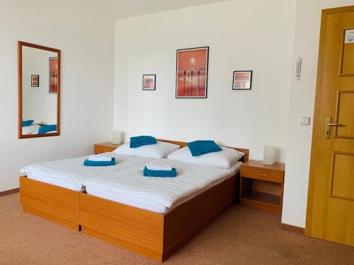 um quarto com uma cama com almofadas azuis e um espelho em Penzion G em Šumperk