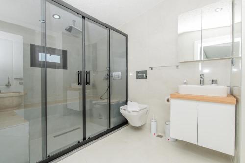 a bathroom with a shower and a toilet and a sink at Eco Villa ECE in Kalkan