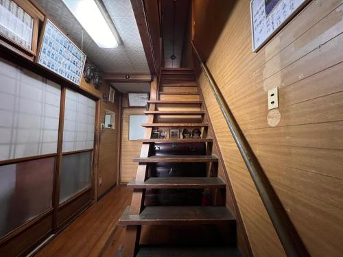 - un escalier dans une salle de train avec des murs en bois dans l'établissement Ryokan Sanki, à Kyoto