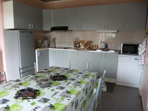 une cuisine avec une table recouverte d'une nappe dans l'établissement La Chaussee Des Ponts, à Noyers-sur-Cher